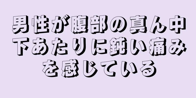 男性が腹部の真ん中下あたりに鈍い痛みを感じている