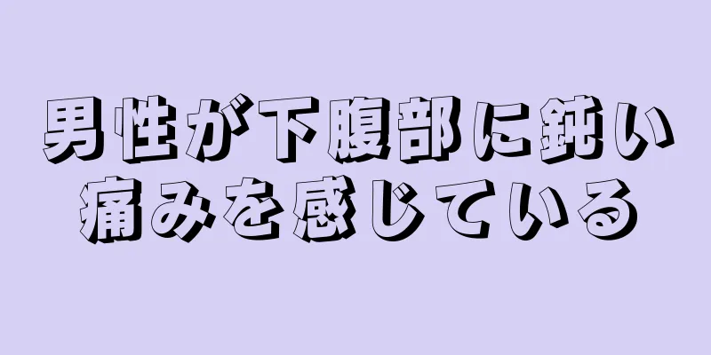 男性が下腹部に鈍い痛みを感じている